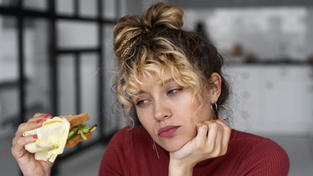 Kobieta na zdjęciu zastanawia się, co jeść, żeby schudnąć.