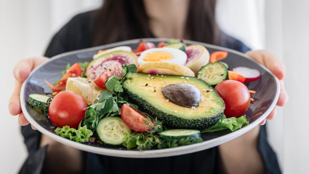 Na zdjęciu lekkostrawne jedzenie prezentowane przez kobietę na talerzu.