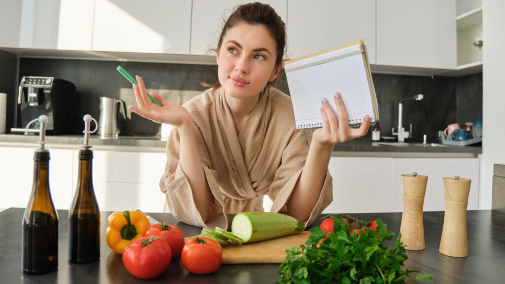 Na zdjęciu kobieta stosująca post przerywany. Zasady rozpisuje na kartce.