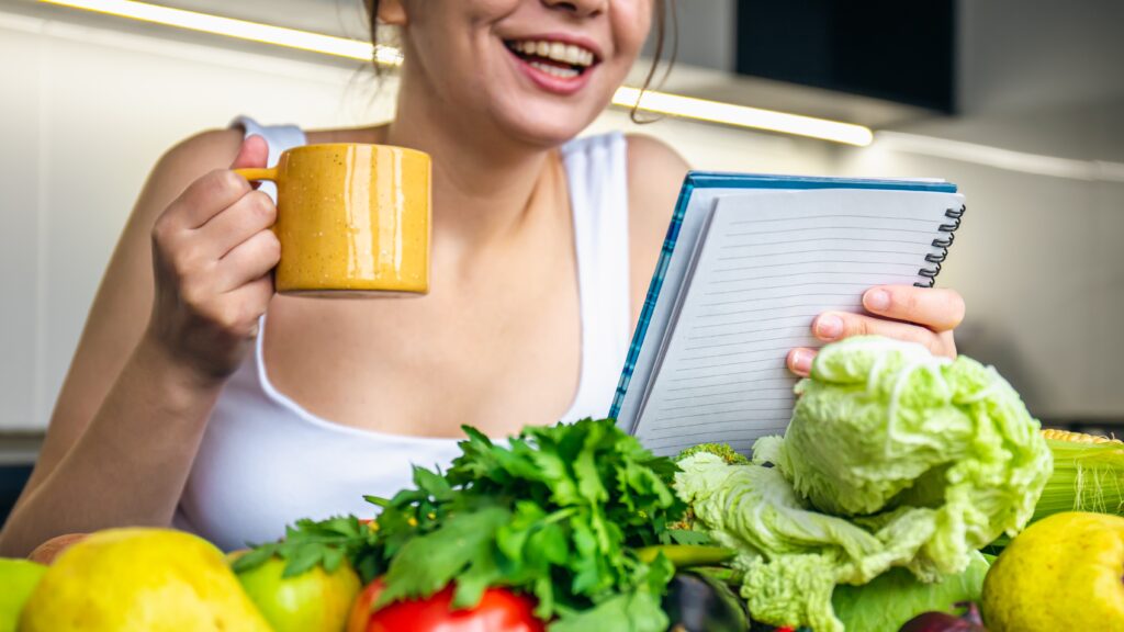 Na zdjęciu młoda kobieta obliczająca swój deficyt kaloryczny.